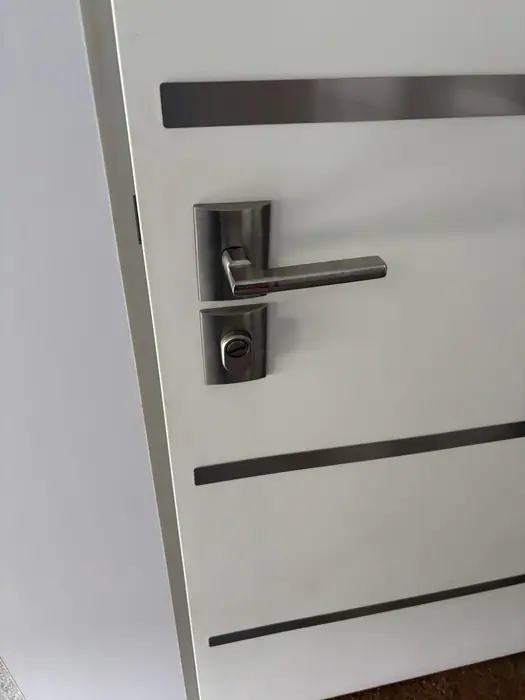 Drzwi wejściowe w Pucku po awaryjnym otwarciu i montażu szyldu zabezpieczającego wkładkę